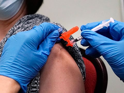 A woman receives a COVID-19 vaccine injection by a pharmacist at a clinic in Lawrence, Massachusetts, on December 29, 2021.