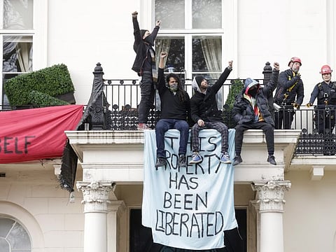 Police, right, prepare to remove people protesting the invasion of Ukraine from occupying a mansion, reportedly owned by members of billionaire Oleg Deripaska's family, in London, U.K., on Monday, March 14, 2022.
