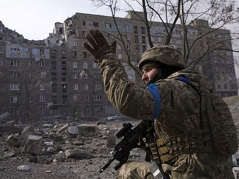 A Ukrainian serviceman guards his position in Mariupol, Ukraine, Saturday, March 12, 2022.