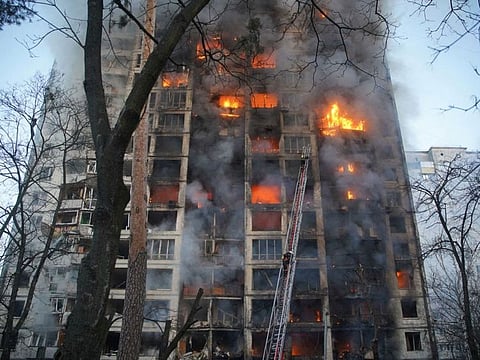 Rescuers work next to a residential building damaged by shelling by Russian troops, in Kyiv.