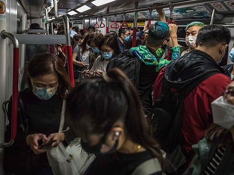 People commute on a train in Hong Kong on March 15, 2022.