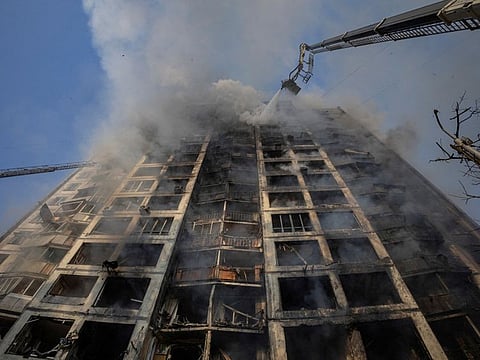 Firefighters work to put out a fire in a residential apartment building after it was hit by shelling in Kyiv, on March 15, 2022.