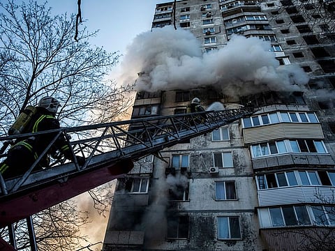 Firefighters try to extinguish a fire at a high-rise apartment building after the predawn missile attack in Kyiv.