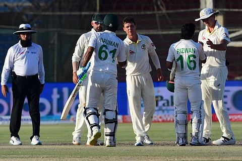 Australian skipper Pat Cummins congratulates Mohammed Rizwan while Nauman Ali shakes hands with spinners Nathan Lyon and Mitchell Swepson at the end of the second Test at the National Cricket Stadium in Karachi on Wednesday.