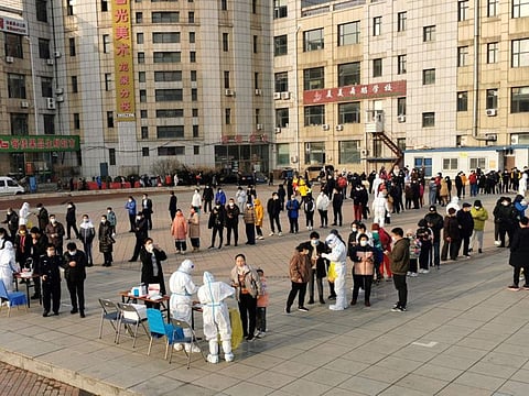 Residents queue to undergo nucleic acid tests for the COVID-19 in Dalian, in China's northeastern Liaoning province on March 16, 2022.