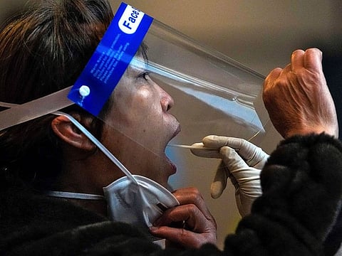 A sample is collected from a worker at a COVID-19 testing site in the Yanqing district of Beijing, China, on March 17, 2022. A fast-spreading variant known as "Stealth Omicron" is testing China’s zero-tolerance strategy, which had kept the virus at bay since the deadly initial outbreak in the city of Wuhan in early 2020.
