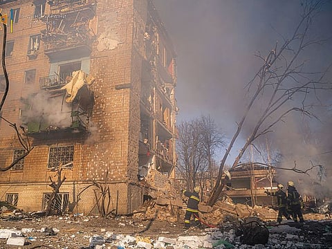 Rescuers work next to a residential building damaged by shelling, in Kyiv, Ukraine, on March 18, 2022.