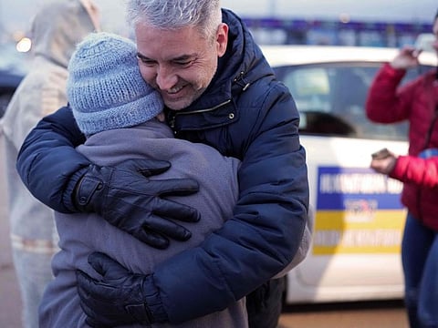 A taxi driver hugs one of the Ukrainian refugees carried by the convoy of Spanish taxi drivers, during a stop in Burgos, on March 16, 2022.