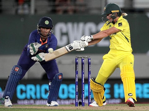 Australia's Meg Lanning cuts one during her match-winning innings of 97 and Indian wicketkeeper Richa Ghosh looks on during their ICC Women's World Cup game on Saturday.