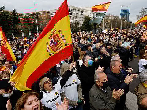 People hold Spanish flags as they take part in a demonstration organised by Spanish far-right party Vox, to protest against energy price hikes, in Madrid, on March 19, 2022.