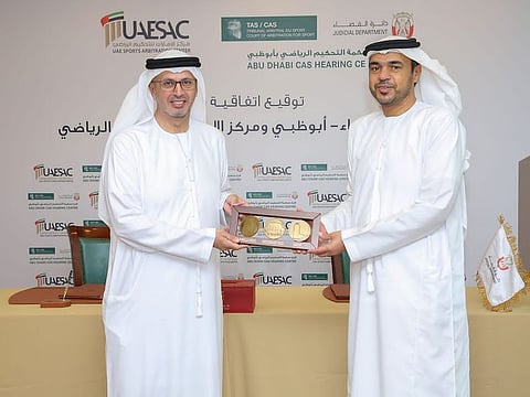 Dirar Belhoul Al Falasi (L) and Ahmad Ibrahim Al Marzouqi exchanging memorial gifts after signing the agreement