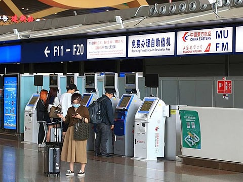Passengers check in at the self-service machines of China Eastern Airlines in Kunming Changshui International Airport in China's southwestern Yunnan province on March 21, 2022, after a China Eastern aircraft flying from Kunming to the southern hub of Guangzhou crashed in southwestern China.