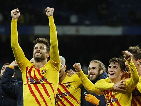 FC Barcelona's Gerard Pique and teammates celebrate after beating Real Madrid 4-0 at the Bernabeu last night.