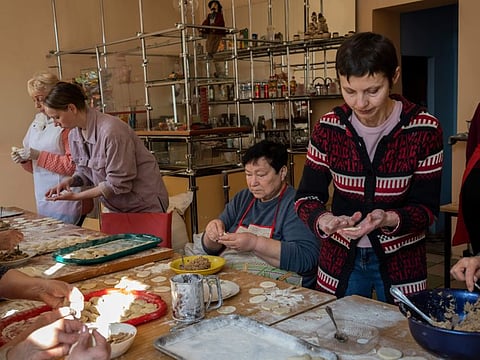 Volunteers prepare varenyky, stuffed dumplings, inside a theatre in the city of Drohobych, western Ukraine, Monday, March 21, 2022. The theatre has become a meeting point, where artistes, including those displaced from other parts of Ukraine, have turned their talents to making food for soldiers and others as part of a massive volunteer war effort across the country.