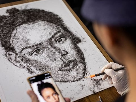 Artist and Filipino seafarer Jesstoni Garcia works on a portrait of Rihanna, made out of human hair, in San Juan City, Philippines.