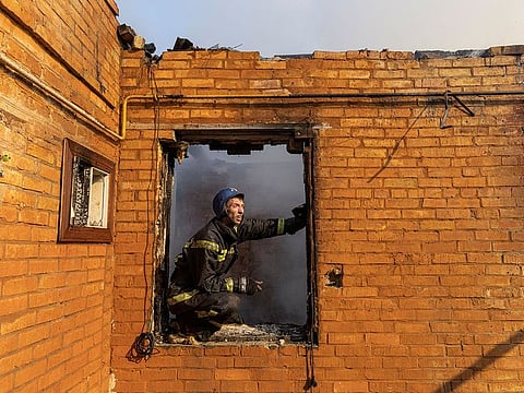 A firefighter works at a residential district that was damaged by shelling, in Kyiv, on March 23, 2022.