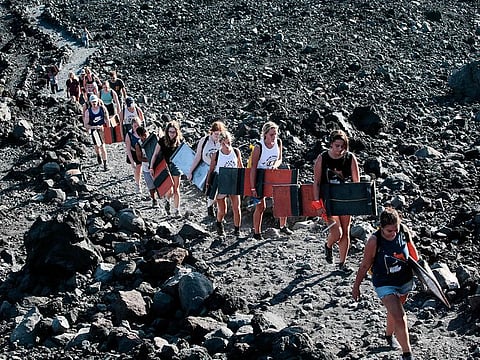 Tourists climb the Cerro Negro volcano, the youngest in Central America (167 years old) and one of the most active in the country, to later surfing down its slopes in Leon, Nicaragua.