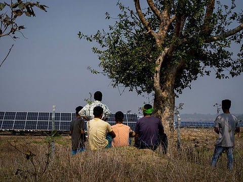 Farmers who’s agriculture lands occupied look at the solar power plant in Mikir Bamuni village in Nagaon district east of Gauhati, India.