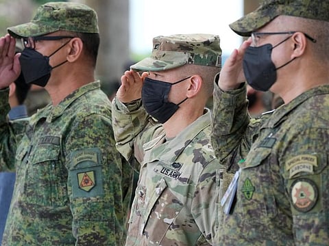 Philippine and US soldiers salute their flags as the national anthem is played during opening ceremonies of the “Balikatan” or “Shoulder to Shoulder” joint military exercises at Camp Aguinaldo, Quezon city, Philippines on Monday, March 28, 2022.