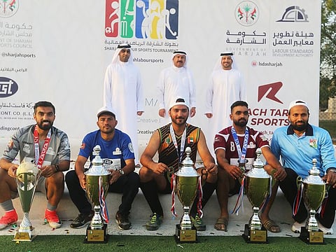 The five winning team captains from the Sharjah Labour Sports Tournament with their trophies.