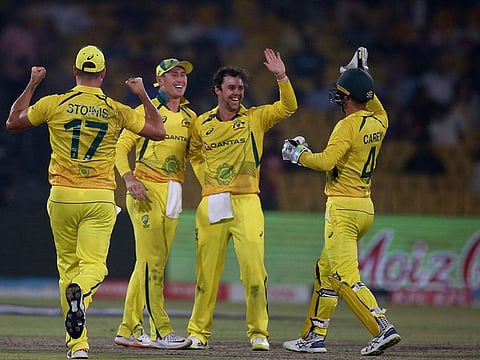 Australia's Travis Head celebrates with teammate after taking the wicket of Pakistan's Saud Shakeel