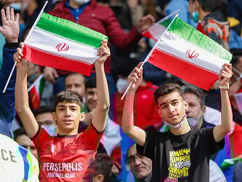 Iran supporters wave the national flag during the 2022 Qatar World Cup Asian Qualifiers football match between Iran and Lebanon, at the Imam Reza Stadium in the city of Mashhad, on March 29, 2022.