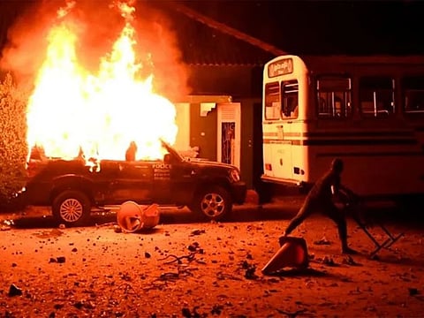 A police car burns on March 31, 2022 during a demonstration outside the Sri Lankan president's home.