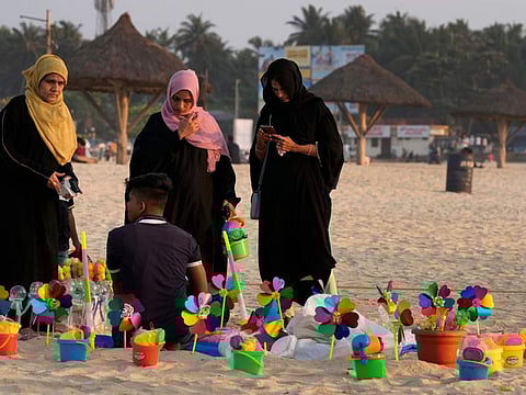 Indian Muslim women wearing hijabs buy toys for their children as they spend an evening at a beach in Udupi, Karnataka state.