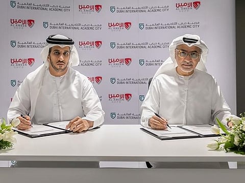 Omar Al Felasi (L) from Al Ameen Service and Mohammed Abdullah from DIAC signing the agreement