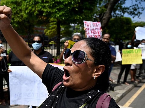 Protestors hold banners and placards during a demonstration against the surge in prices and shortage of fuel and other essential commodities in Colombo on April 4, 2022.