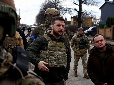 Ukraine's President Volodymyr Zelenskiy gestures as he is surrounded by Ukrainian servicemen as Russia's war in Ukraine continues, in Bucha, outside Kyiv, Ukraine, April 4, 2022.