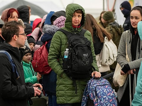 Refugees wait in a line after fleeing the war from neighbouring Ukraine at the border crossing in Medyka, southeastern Poland, Tuesday, April 5, 2022.