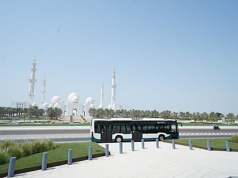 A bus drives past the Sheikh Zayed Grand Mosque in Abu Dhabi