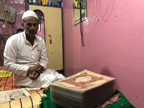 Rafeeq Ahmed Ghawwas with his prized possession of a 17th century calligraphed copy of Quran, at his tiny home in Belgaum.