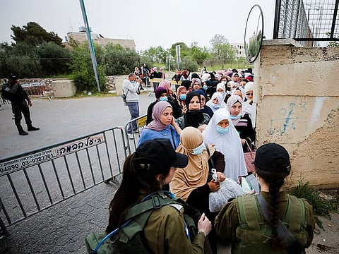 Palestinians make their way through an Israeli checkpoint to attend the first Friday prayers of Ramadan in Jerusalem’s Al Aqsa mosque, in Bethlehem.