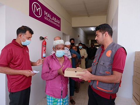 Team members from Malabar Gold and Diamonds distribute iftar meals.