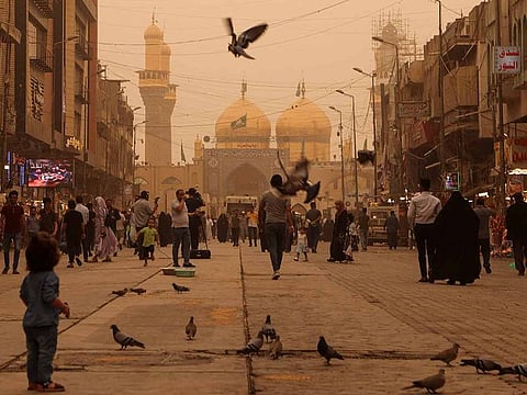 Birds fly near Imam Moussa Al Kadhim shrine, during a sandstorm in Baghdad's Kadhimiya district, Iraq, on April 9, 2022.