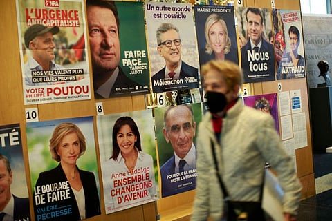A woman passes posters of candidates as French citizens arrive to cast their vote in the presidential election at the Lycée Français in New York City on April 09, 2022.