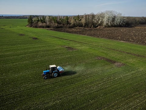 An aerial view shows a tractor spreading fertiliser on a wheat field near the village of Yakovlivka after it was hit by an aerial bombardment outside Kharkiv.