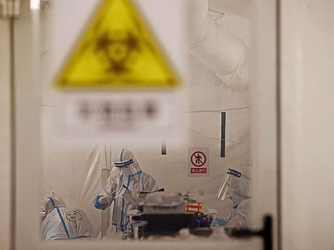Workers in protective suits work inside a makeshift nucleic acid testing laboratory, following the coronavirus disease (COVID-19) outbreak in Shanghai, China April 11, 2022.