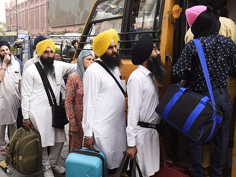 Sikh pilgrims queue to board a bus before leaving to Pakistan for 'Baisakhi', a spring harvest festival for Sikhs and Hindus, in Amritsar on April 12, 2022.