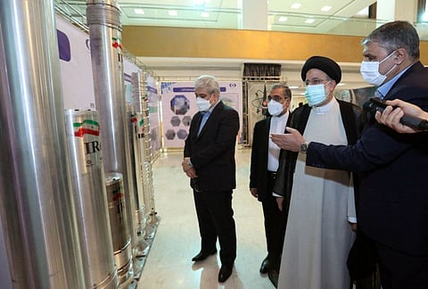 President Ebrahim Raisi (second right) accompanied by the Atomic Energy Organisation of Iran (AEOI) chief Mohammad Eslami (right) attending an event during the "Nuclear Technology Day" in the capital Tehran on April 9, 2022.