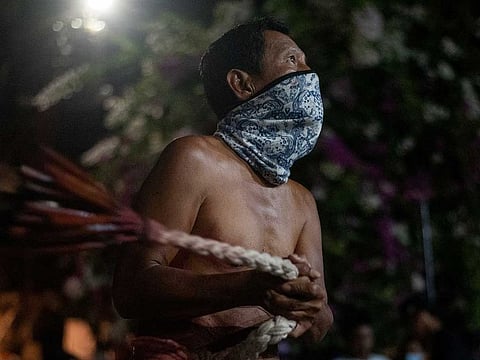A penitent performs self-flagellation outside a church, during Good Friday, in Navotas, Metro Manila, Philippines, April 15, 2022.