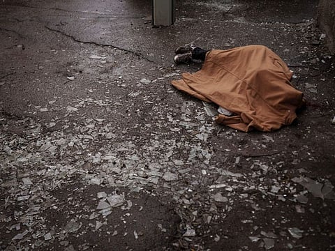 The body of a woman killed a Russian bombardment lies covered on a sidewalk in downtown Kharkiv, April 17, 2022.