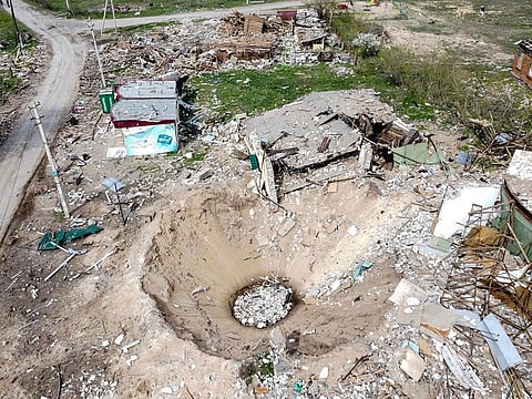 An aerial view shows a crater and a destroyed home in the village of Yatskivka, eastern Ukraine on April 16, 2022.