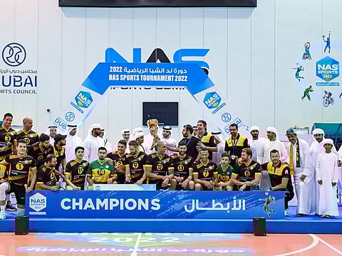 Sheikh Mansoor awarding Emperor team captain with the trophy after winning the volleyball title in the NAS Sports Tournament on Tuesday.
