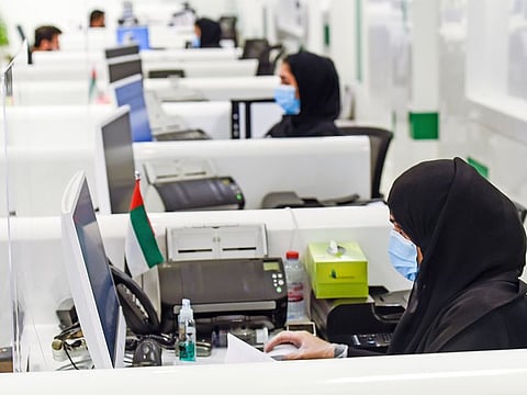 Amer centre staff processing visa applications in Dubai.