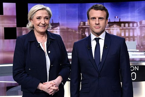 In this file photo taken on May 3, 2017 French presidential election candidate for the far-right Rassemblement national (RN), formerly known as Front National (FN) party, Marine Le Pen (L) and French presidential election candidate for La Republique En Marche (LREM) movement, Emmanuel Macron pose prior to the start of a live brodcast televised debate on the French public national television channel France 2 and French private channel TF1 in La Plaine-Saint-Denis, north of Paris, as part of the second round of election campaign.