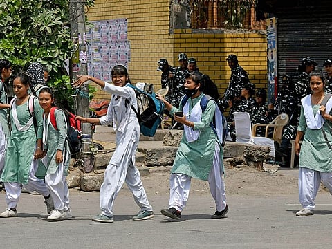Students come out of a school in New Delhi, India