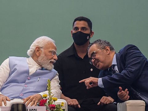 India’s Prime Minister Narendra Modi (L) speaks with Director-General of the World Health Organization (WHO) Tedros Adhanom Ghebreyesus during the Global Ayush Investment and Innovation Summit in Gandhinagar on April 20, 2022.